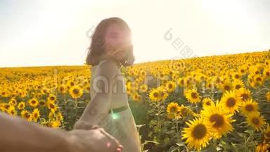 爸爸和女儿沿着田野走着，夕阳下，向日葵牵着手，第一人称的<strong>景色</strong>。 慢速<strong>视频</strong>